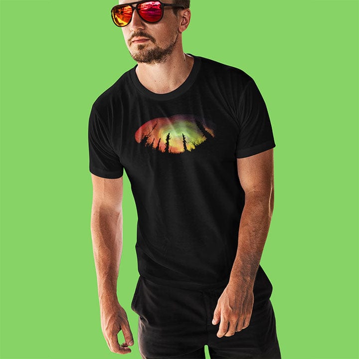Man wearing forest silhouette in front of aurora on black t-shirt for nature mysticism earth sky connection.
