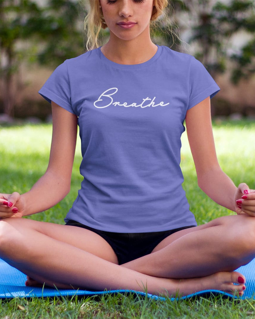 Mediating woman wearing a breathe mediation purple t-shirt for mindfulness spiritual apparel.