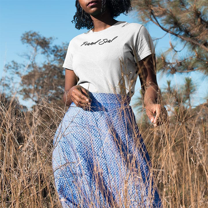 Woman in a field wearing Found Soul® light to dark white t-shirt for courage and going inward.