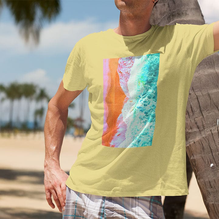 Man at the beach wearing each and waves surf blend yellow t-shirt for healing and coastal peace.