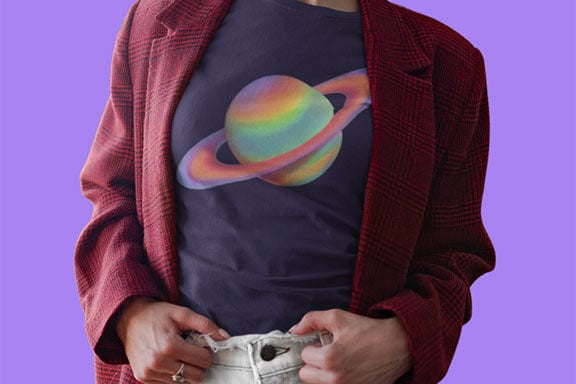 Woman wearing colorful painted Saturn with rings navy t-shirt for cosmic patience and blooming.