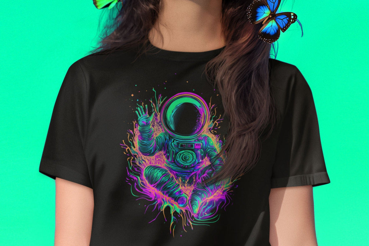 Woman wearing meditating astronaut in nebula and waving hello black t-shirt for cosmic peace and spiritual exploration.