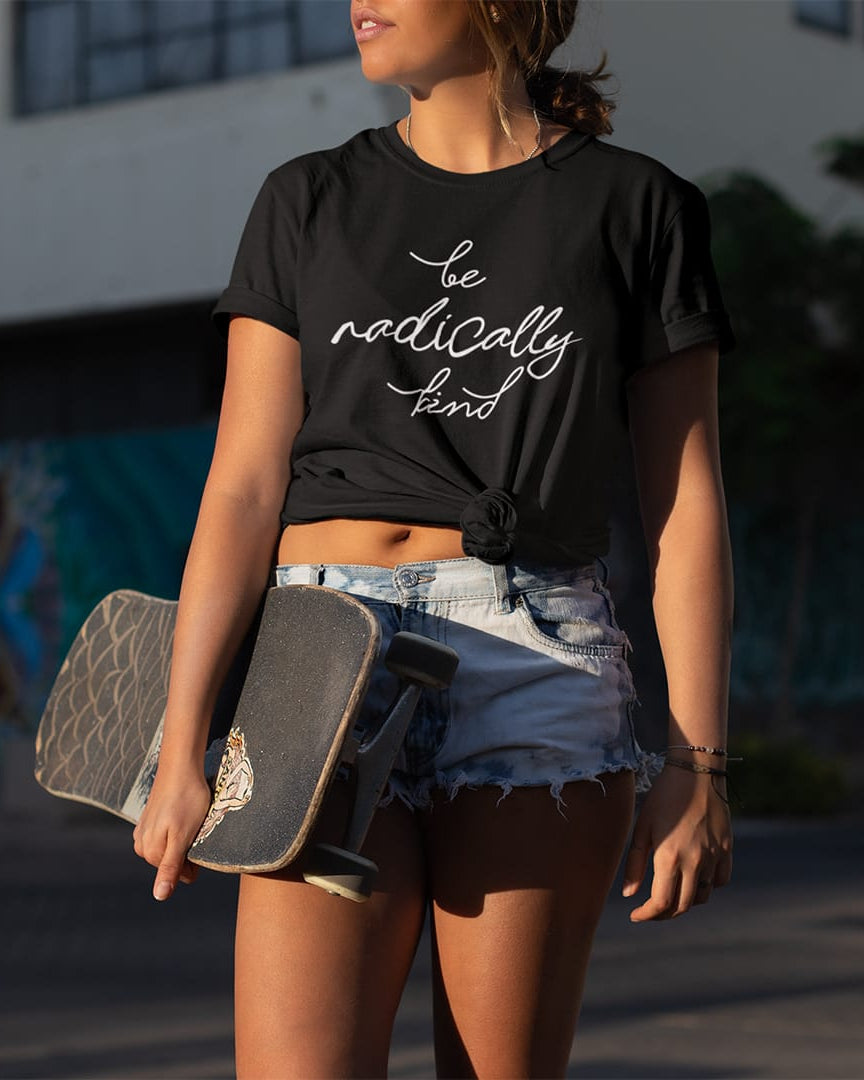 Woman holding a skateboard wearing a be radically kind black t-shirt for compassion and gentle rebellion.