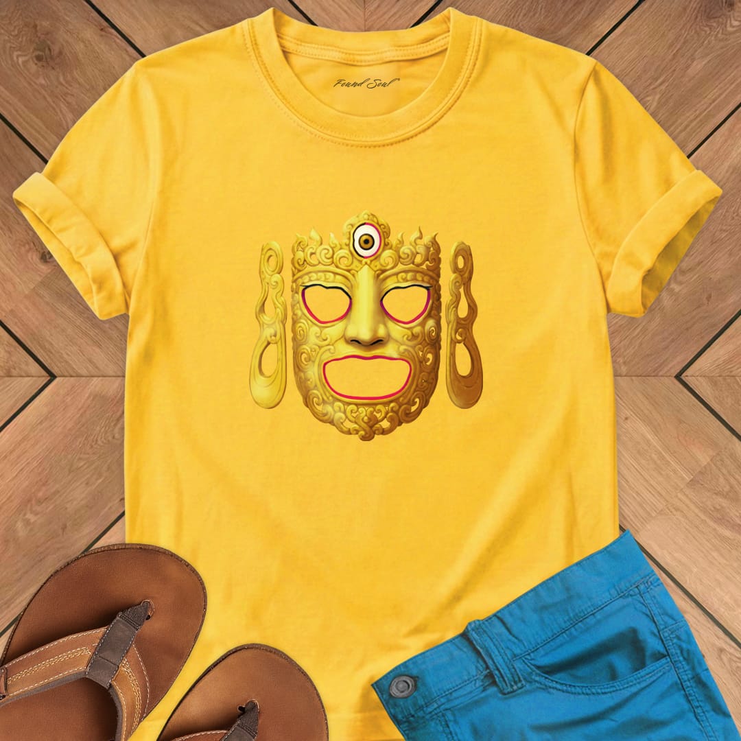 Ornate Buddha ceremonial dance mask on yellow t-shirt for Buddhist ritual sacred vessel mystery tradition
