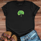 Glowing green ginkgo leaf with radiating light black t-shirt for renewal and fresh starts.