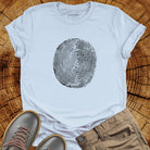 Tree ring and thumbprint design in white on light blue t-shirt for nature identity growth layers spiritual connection
