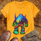 Bigfoot silhouette filled with aurora borealis and forest landscape on yellow t-shirt for cryptid mystery wilderness.